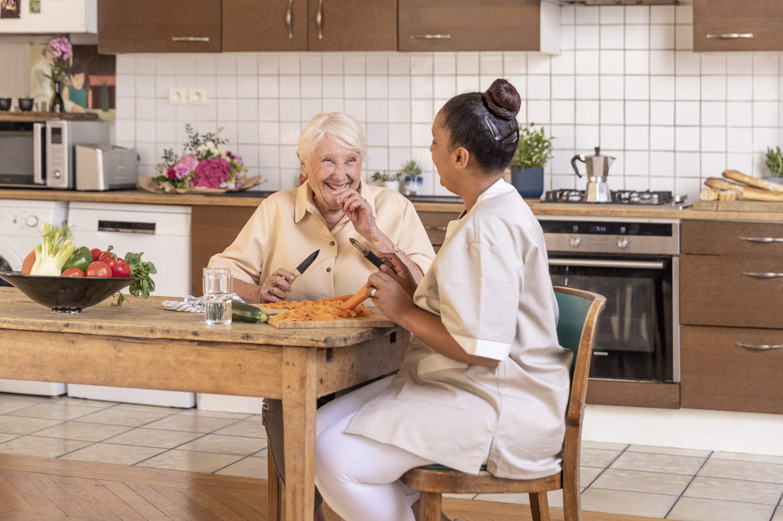 Carer spending time with an older woman at home